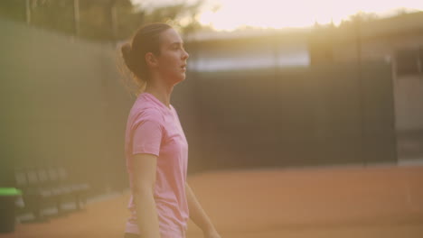 The-girl-is-tired-during-tennis-training-on-an-open-court-with-a-dirt-surface.-slowly-approaches-the-ball-and-hits-it-with-a-backhand